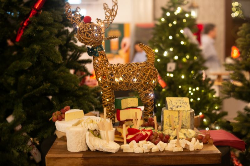 Cheese board surrounded by Christmas trees and a decorative reindeer